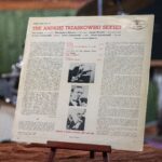 Płyta winylowa w papierowej okładce. Seant – Polish Jazz Vol. 11. [Sient – Polisz Dżez] Andrzej Trzaskowski Sextet. Wytwórca: Muza Polskie Nagrania. Polska – tysiąc dziewięćset sześćdziesiąt dwa. Wymiary: płyta o średnicy trzydziestu centymetrów, koperta kwadratowa o boku trzydzieści na trzydzieści centymetrów. Rewers okładki płyty. Od góry tytuł i wykonawcy: Ted Curson, Włodzimierz Nahorny, Janusz Muniak, Andrzej Trzaskowski, Jacek Ostaszewski, Adam Jędrzejowski.