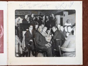 Zdjęcie z autografami. Wizyta zespołu Andrzeja Trzaskowskiego w USA. Zdjęcie wykonano z Broadway New York Club Birdland [Brodłej Nju Jork Klab Birdlend]. Materiał: papier fotograficzny. Miejsce: Ulica Pięćdziesiąta Druga, Nowy Jork, rok tysiąc dziewięćset sześćdziesiąty drugi. Wymiary: dwadzieścia pięć na dwadzieścia centymetrów. Czarno-białe zdjęcie w białym passe-partout