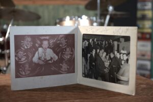 Zdjęcie z autografami. Wizyta zespołu Andrzeja Trzaskowskiego w USA. Zdjęcie wykonano z Broadway New York Club Birdland [Brodłej Nju Jork Klab Birdlend]. Materiał: papier fotograficzny. Miejsce: Ulica Pięćdziesiąta Druga, Nowy Jork, rok tysiąc dziewięćset sześćdziesiąty drugi. Wymiary: dwadzieścia pięć na dwadzieścia centymetrów. Czarno-białe zdjęcie w białym passe-partout