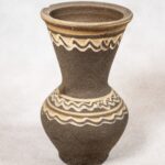 Siwak. Twórca: Stanisław Stępowski. Materiał: glina wypalana. Naczynie z okrągłym otworem od góry. Naczynie poniżej otworu zwęża się lejkowato, niżej uwypukla, by ostatecznie zwęzić się przy podstawie. Siwak jest matowy, ciemnoszare boki przy otworze i góry wypukłej części ozdobione jasnym wzorem.